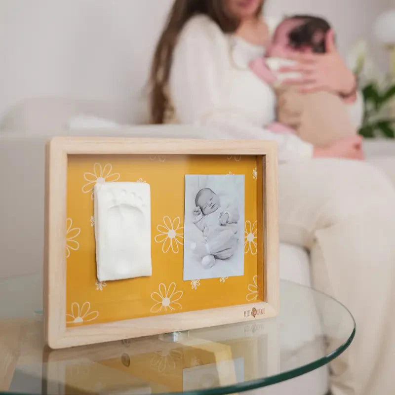 cornice classica in legno con sfondo ocra e motivo margherite, portafoto e impronta digitale per bambini