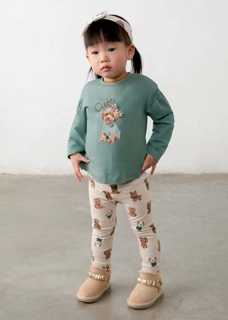Completo leggings per bambina verde salvia con maglietta stampa cane e pantaloni beige con stampa orsacchiotti, fascia rosa chiaro.