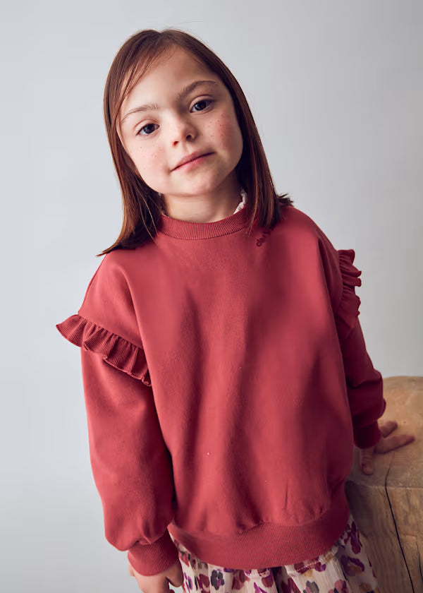 Girl wearing red Felpa VPULANT long sleeve sweatshirt with decorative ruffles on sleeves