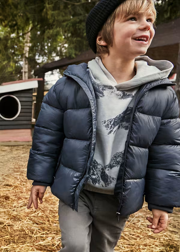 Boy wearing GIACCONE MAYORAL BOY shiny padded jacket with hood and zipper outdoors