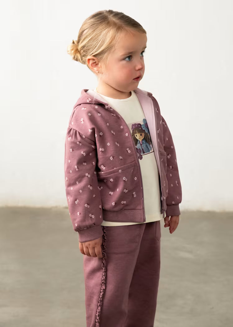 TUTA 3PZ BAMBOLA composta da felpa e pantaloni lilla con cappuccio, stampa floreale e maglia bianca con disegno bambola