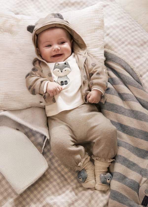 Baby girl wearing TUTA TRICOT 3 PZ beige three-piece outfit with hooded jacket and animal print.